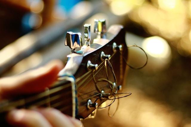 A picture of the tuning pegs of an acoustic guitar.